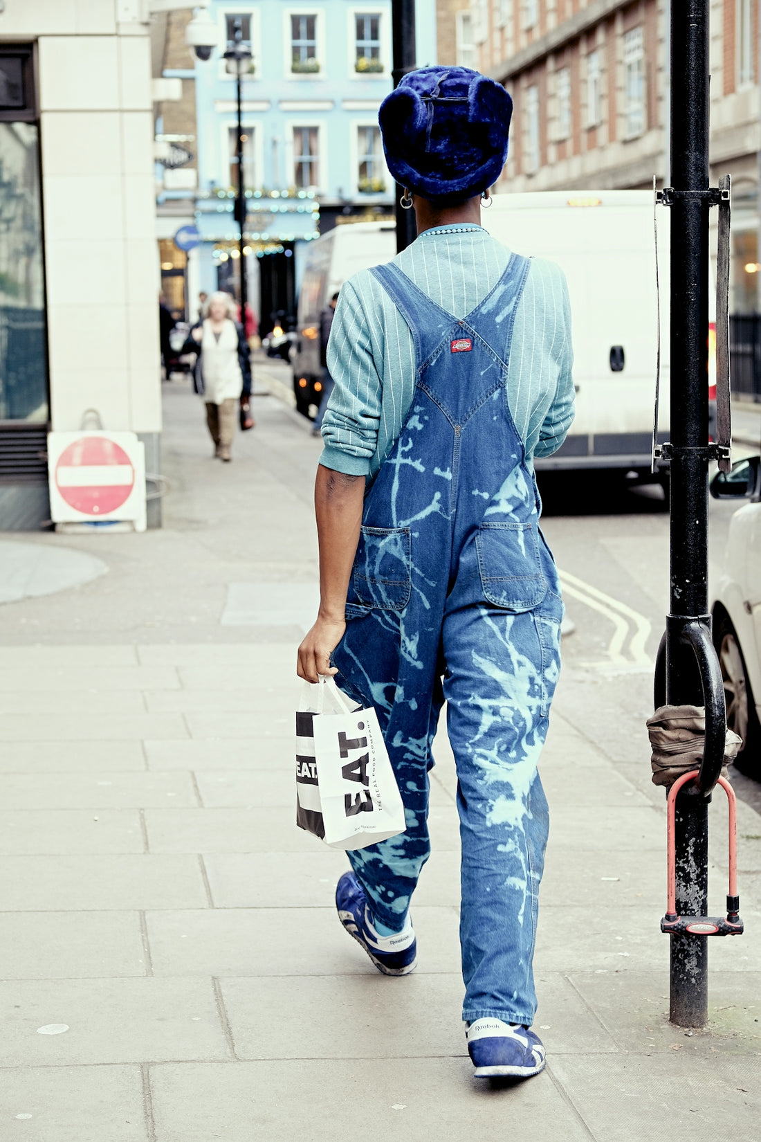walking woman holding EAT bag