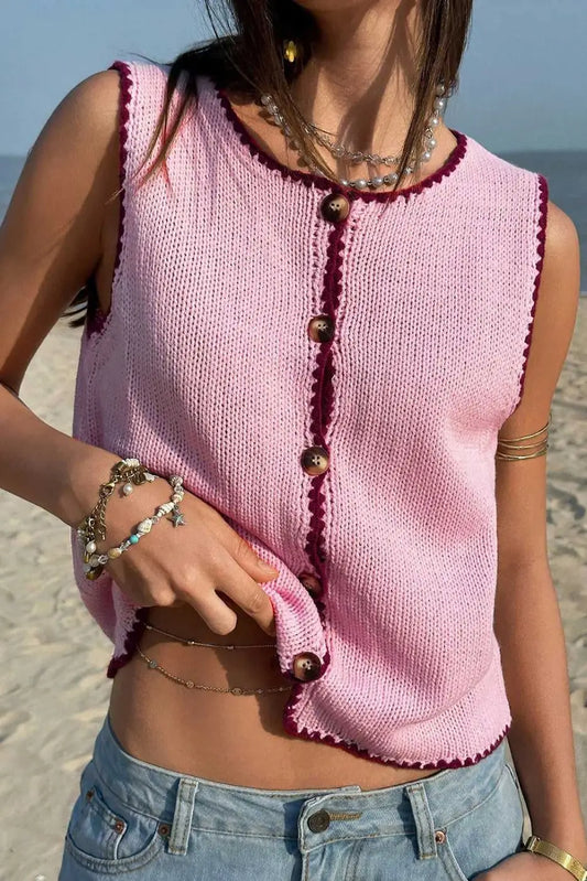 Pink contrast trim knit crop top with wooden buttons, sleeveless design, and stretch fit, styled for summer beachwear.