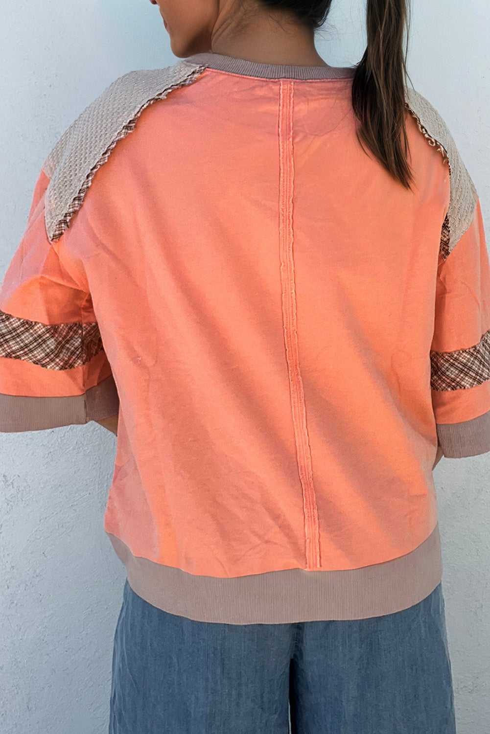 Back view of autumn plaid floral long sleeve top in orange, featuring contrast waffle knit shoulders and plaid sleeve accents.