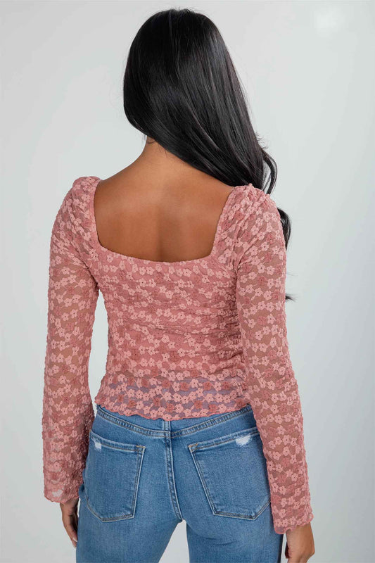 Back view of pink floral lace blouse featuring square neckline and fitted silhouette. Elegant choice for weddings and night-out occasions.