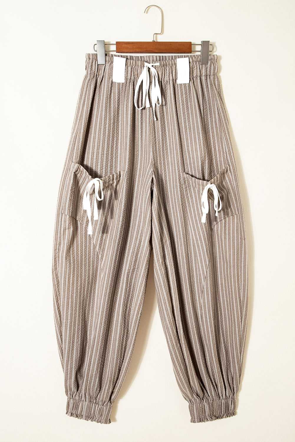 Flat lay of Women's Brown Stripe Cargo Joggers on hanger, highlighting drawstring waist and dual cargo pockets.