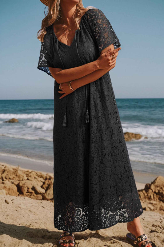 Black Lace Overlay Maxi Sundress with floral lace detail and tassel ties, styled for a beach vacation. Lightweight H-line silhouette for summer comfort.