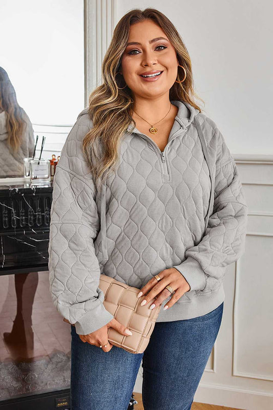 Curve grey quilted quarter-zip hoodie for women styled with jeans, featuring a relaxed fit and cosy texture for casual winter wear.