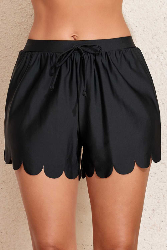 Black scalloped trim beach shorts front close-up
