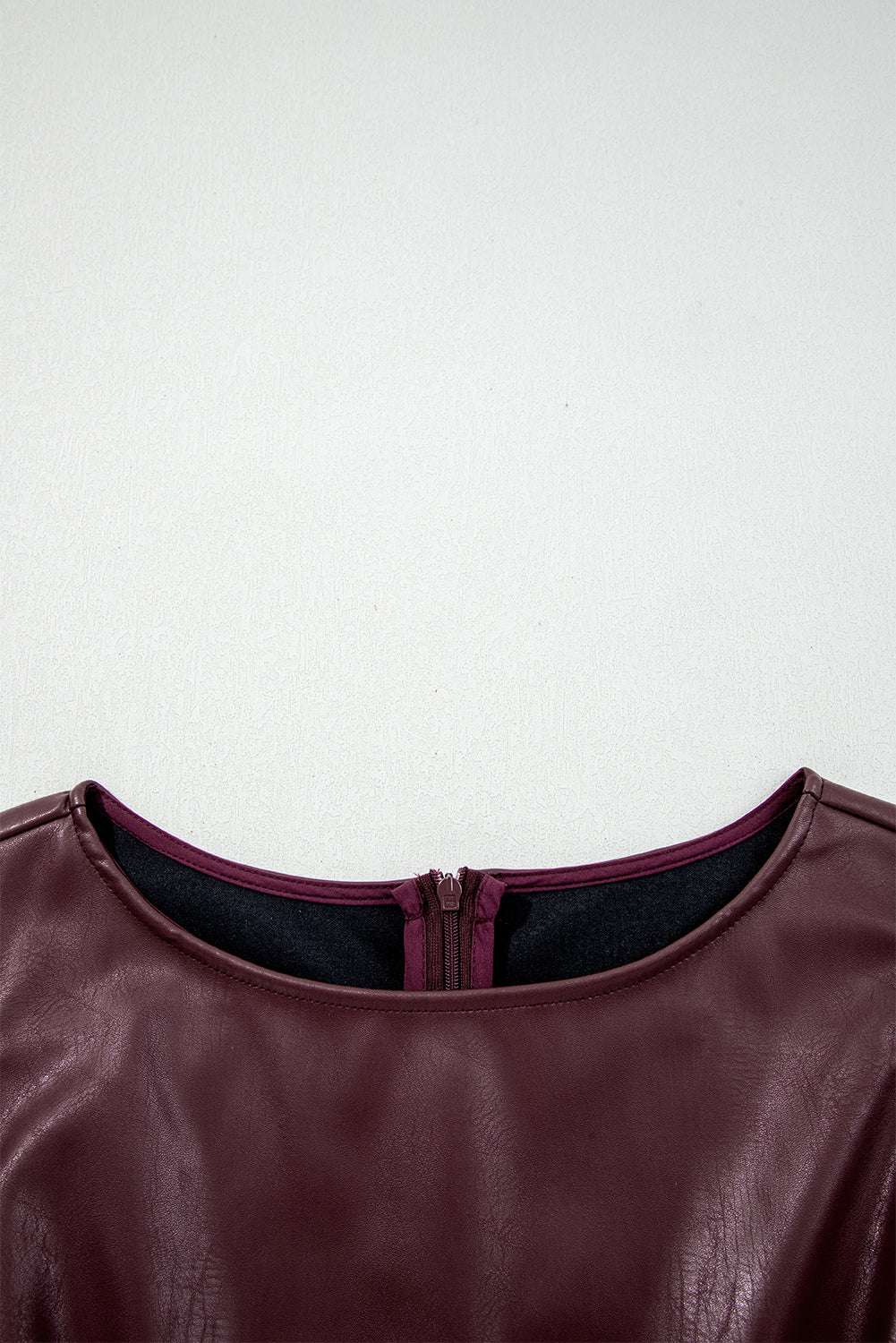 Detailed neckline view of Brown Faux Leather Sleeveless Mini Dress showing inner lining and zipper finish.