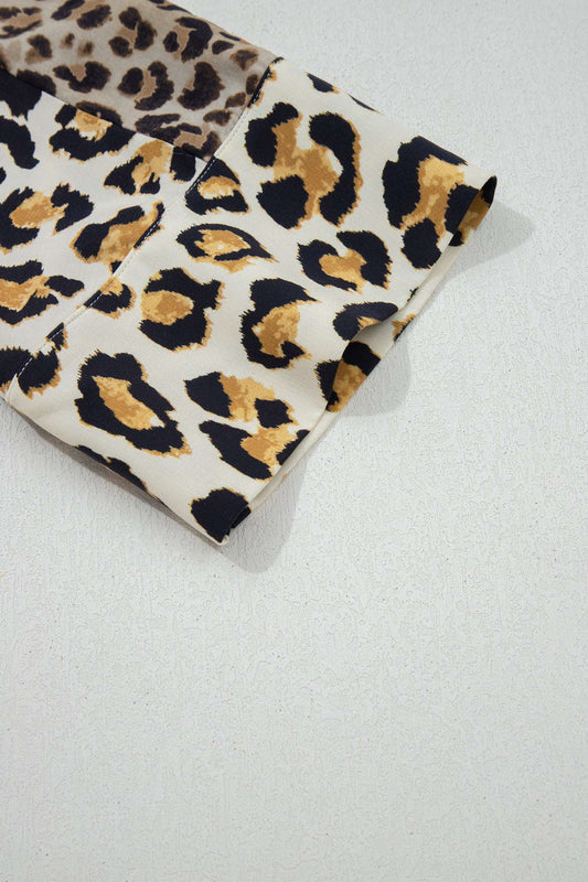 Detail of 3/4 sleeve hem on khaki leopard print shirt highlighting bold animal pattern and soft fabric texture.