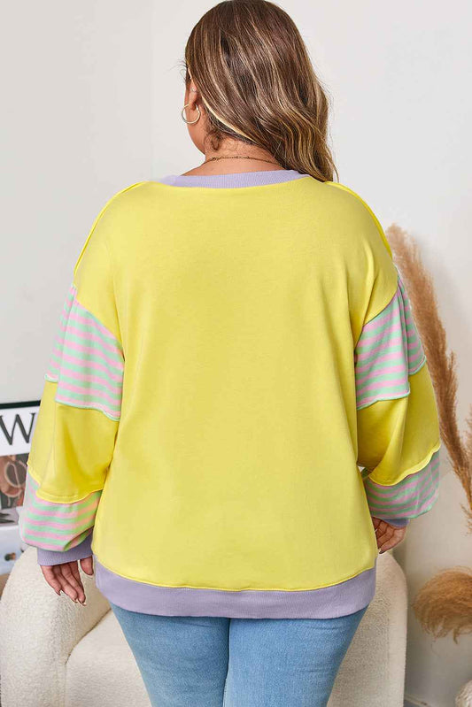 Back view of plus size yellow sweatshirt showing relaxed fit and color block sleeve design for casual comfort.