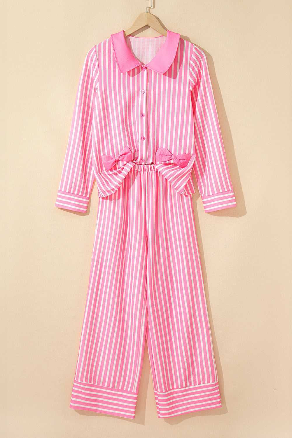pink stripe pyjama set with button-up top and long sleeves on a hanger