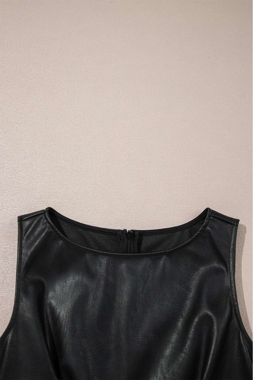 Close-up of neckline on Black Vegan Leather Sleeveless Mini Dress, showing smooth PU leather texture and precise stitching detail.