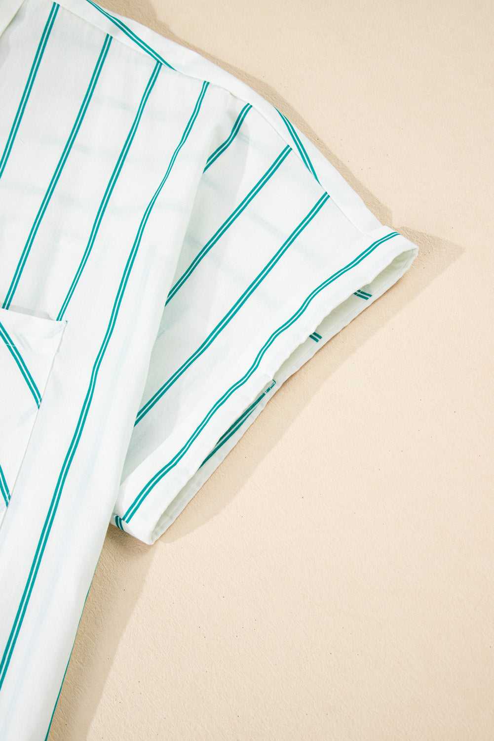 White fabric with green stripes on a beige background