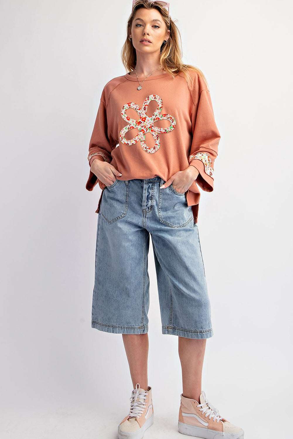 Full-body view of Flower Patch Graphic Top styled with knee-length denim shorts and sneakers, perfect for casual spring fashion.