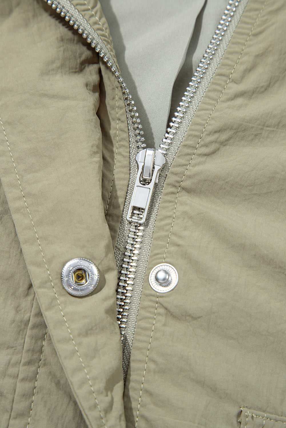 Detail of zipper and snap button closure on Cropped Hooded Utility Jacket, showcasing secure and stylish outerwear construction.