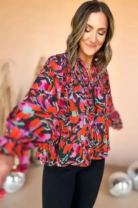 Model twirling in Abstract Floral Shirred Puff Sleeve Blouse | FashionFitz, highlighting the flowy silhouette and bold red, pink, and purple floral pattern.