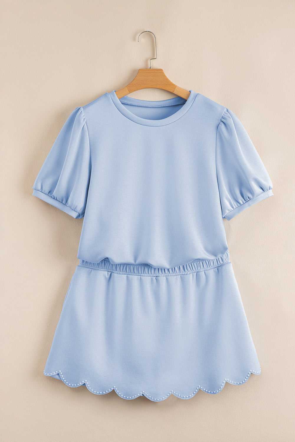 Light blue skort set with scalloped hem on a beige background