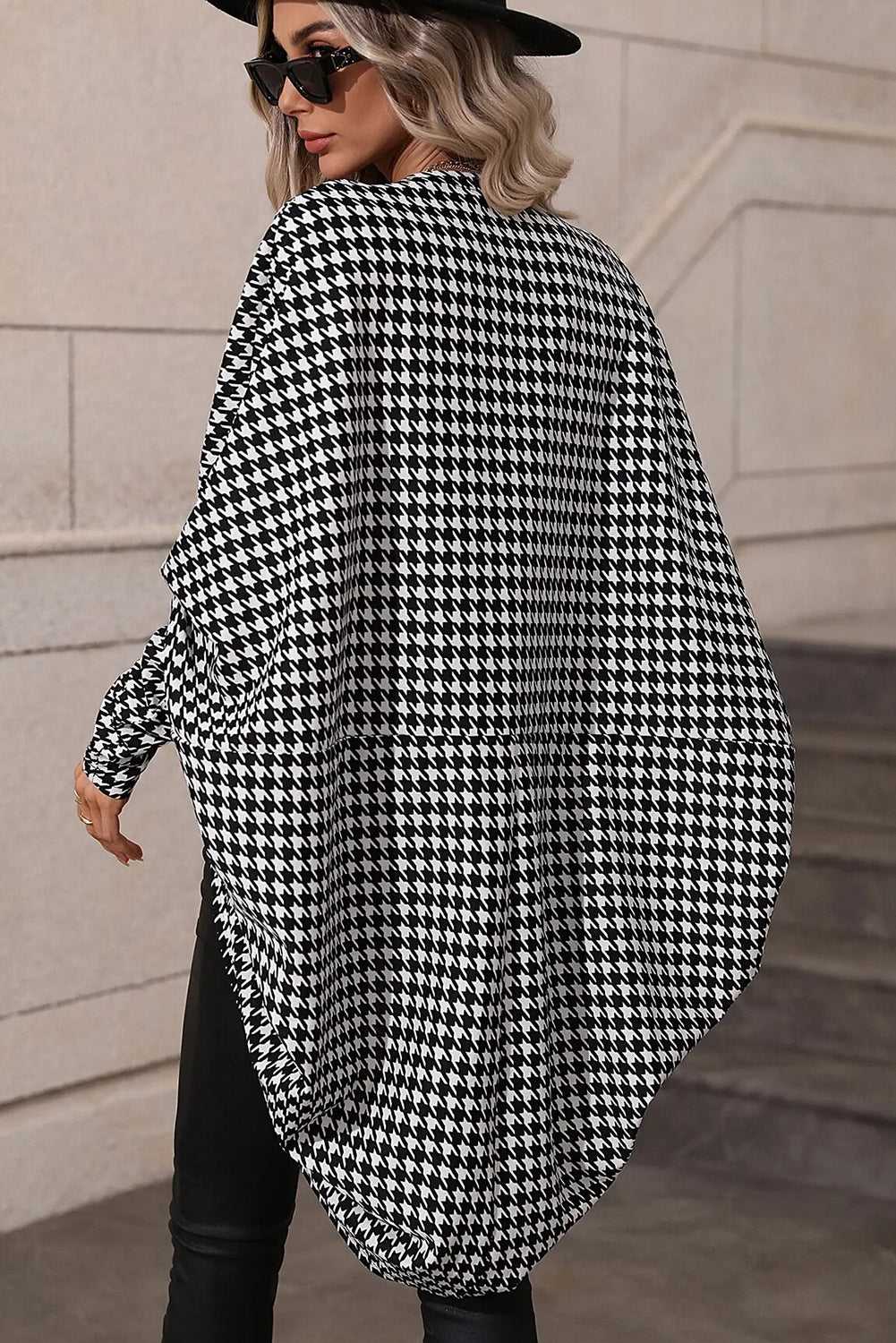 Person wearing a Black Houndstooth Dolman Kimono Wrap against a stone wall.