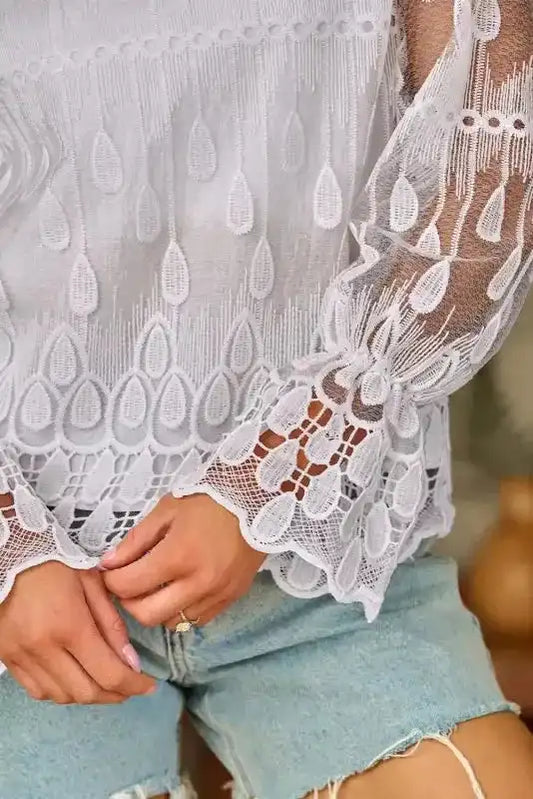 Close-up of flounce sleeve detail on beige embroidered mesh blouse. Features intricate lace and teardrop embroidery for a feminine touch.