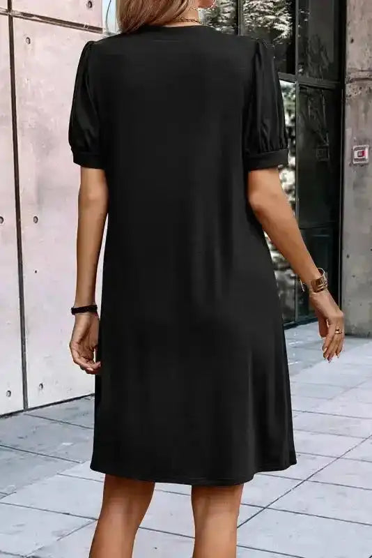 Back view of black Notched Pleat Puff Sleeve Shift T-Shirt Dress showing relaxed fit and short gathered sleeves.