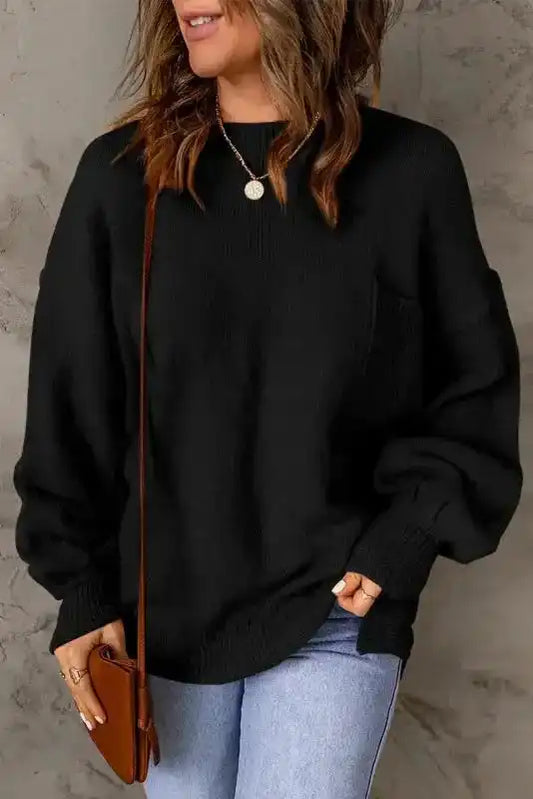 Black puffy sleeve sweater with front pocket and crew neck, styled with light jeans and a brown crossbody bag for casual wear.
