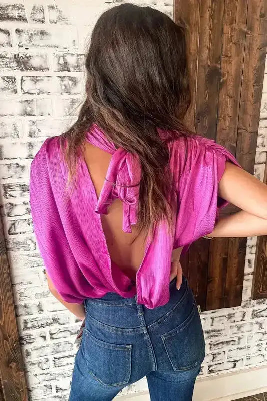 Back view of bright pink knotted backless blouse with ruched sleeves, perfect for night out or summer events.