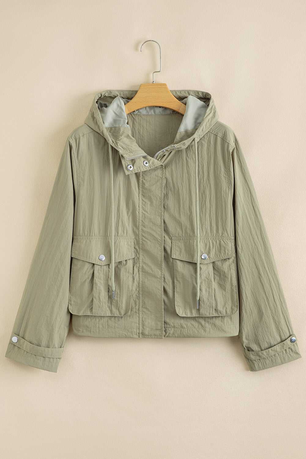 Laurel green Cropped Hooded Utility Jacket on hanger, featuring front zip, snap buttons, and flap pockets for functional outerwear appeal.