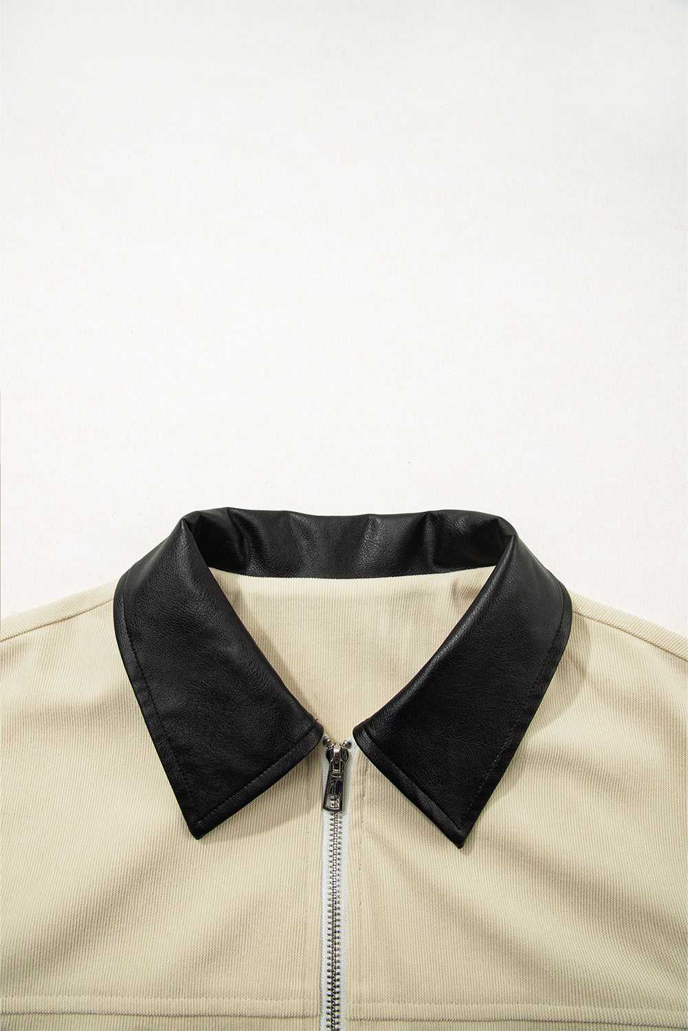 Close-up of black leather collar on the beige corduroy jacket, emphasizing the stylish contrast trim for fall outerwear.