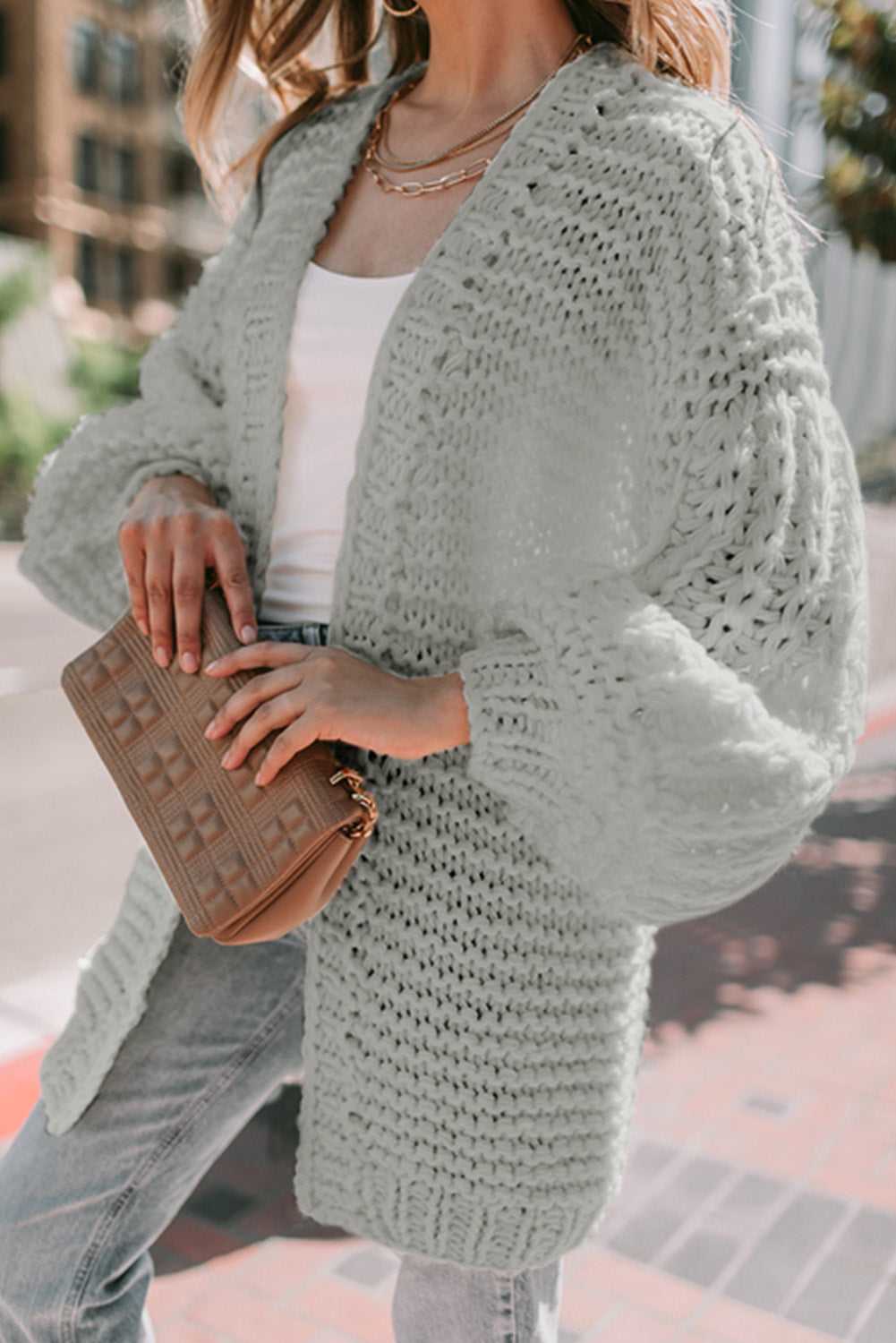 Detail shot of light grey oversized cardigan with thick knit texture and balloon sleeves, styled for a cozy layered look.