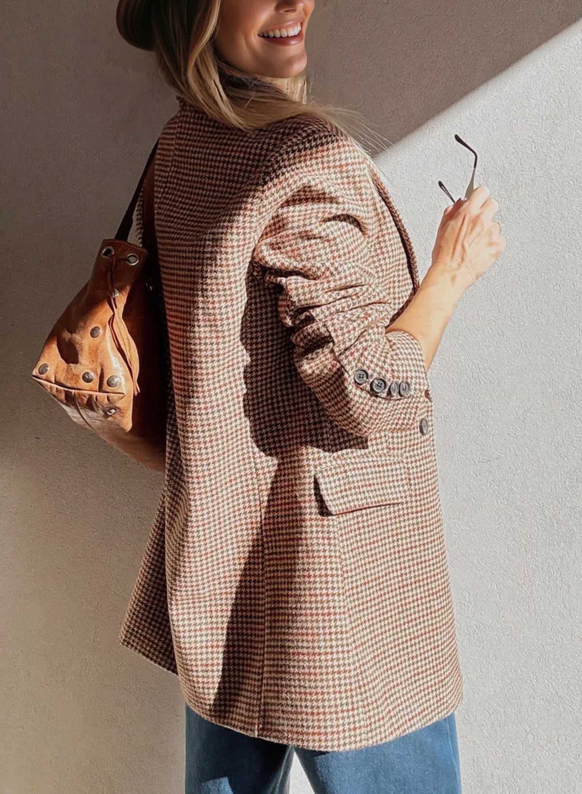 Back view of Ladies Brown Houndstooth Fitted Blazer paired with a brown leather bag, highlighting tailored fit and button details.