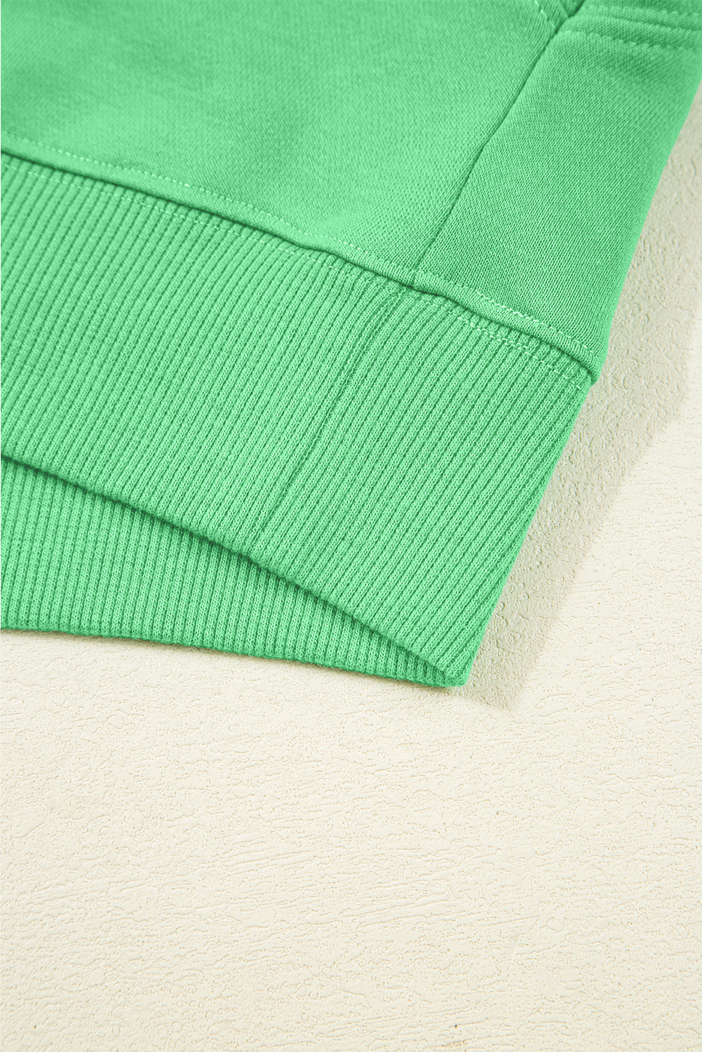 Ribbed hem detail of green Drop Crop top, highlighting quality stitching and casual loungewear style.