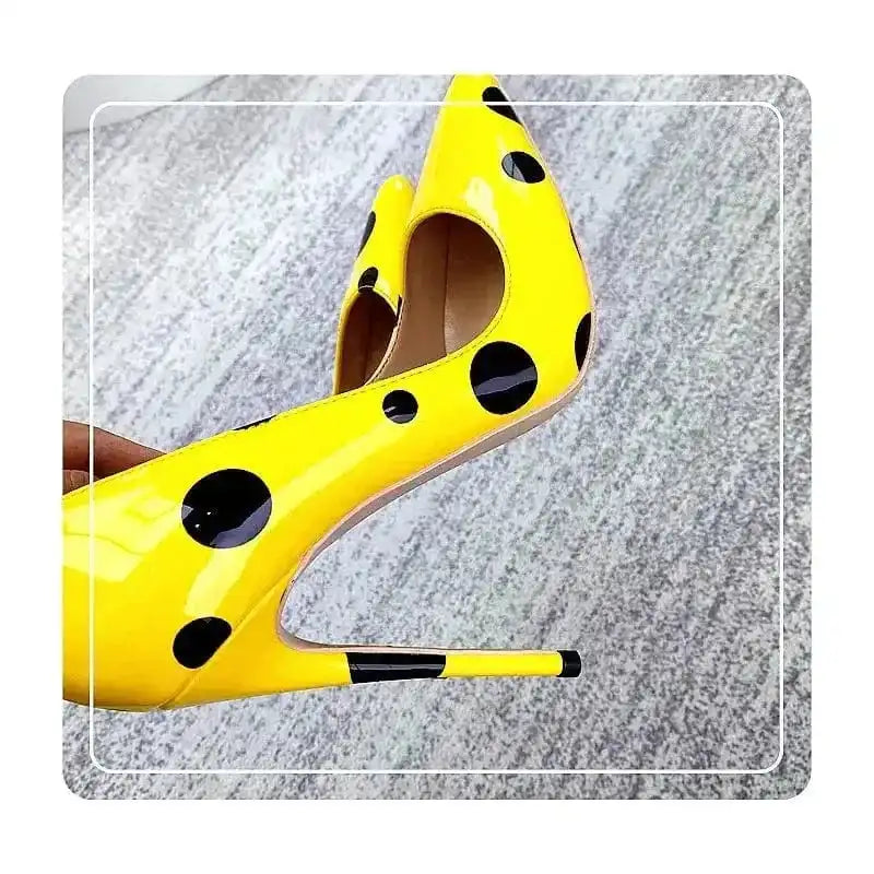 Close-up of Polka Dot Yellow Stiletto High Heels Shoes highlighting pointed toe and slim heel. FashionFitz pumps with bold black dot design.