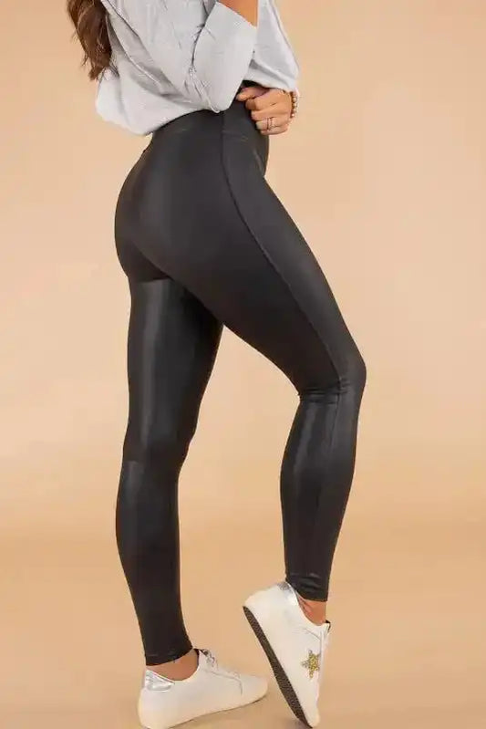 Women’s black faux leather skinny leggings with high-rise waist, shown from side view to highlight sleek bodycon fit and PU leather texture.