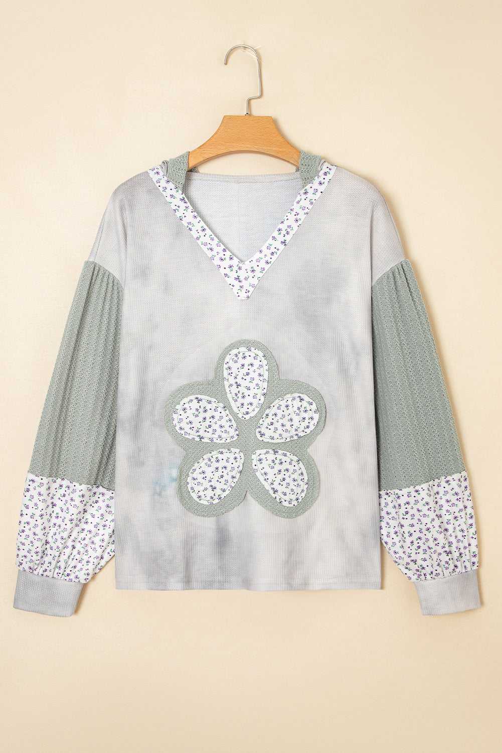 Gray sweater with floral patterns on a beige background