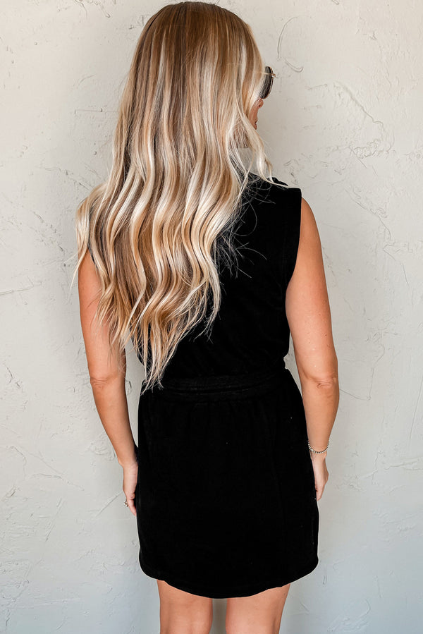 Black French terry mini dress — side view showing zip collar and drawstring waist