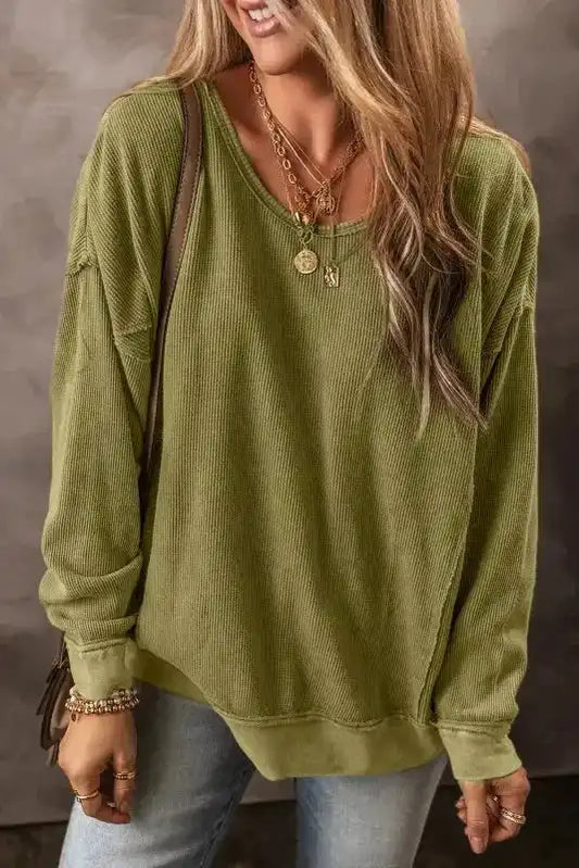 Women's Jungle Green Textured Sweatshirt by FashionFitz styled with layered necklaces and light-wash jeans, perfect for casual winter wear.