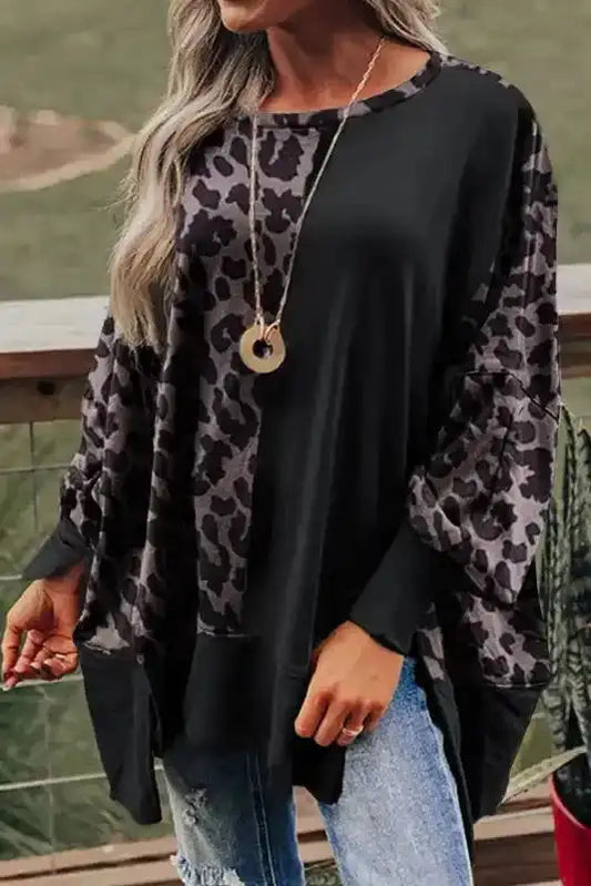 Leopard Patchwork Bishop Sleeve Sweatshirt with side slits, featuring bold leopard print sleeves and relaxed black body for a trendy winter look.