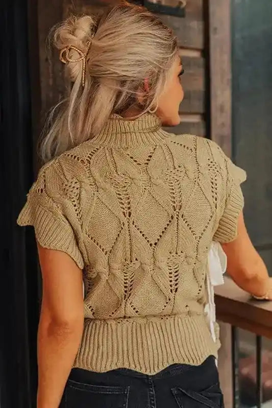 Back view of beige high neck knit sweater featuring intricate crochet pattern and scalloped hem, ideal for daily winter wear.