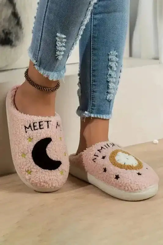 Light pink fuzzy slippers featuring moon and clock embroidery, perfect for cozy winter wear at home with casual outfits.