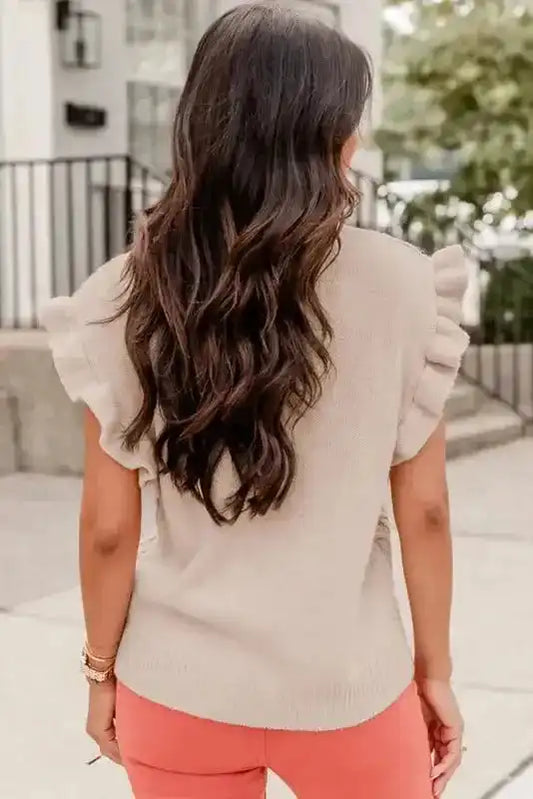 Back view of oatmeal plus cable knit short ruffled sleeve sweater showing ribbed hem and soft ruffle sleeve detail for a casual spring look.