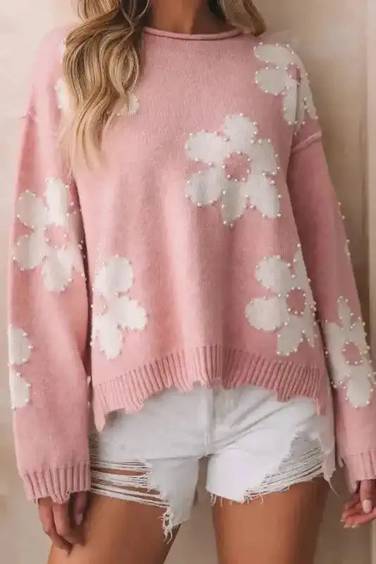Ladies Pink Pearl Beaded Floral Sweater by FashionFitz styled with white distressed shorts, featuring white floral patterns and pearl accents.