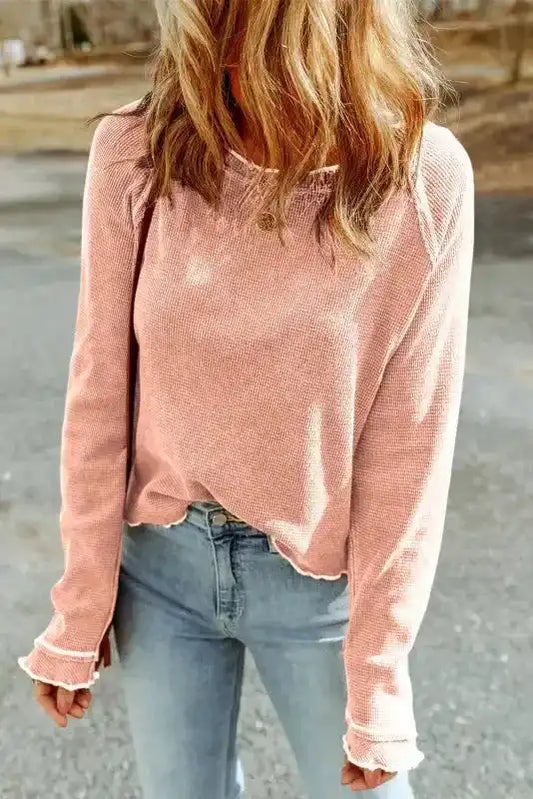 Apricot pink textured round neck long sleeve top styled with light denim jeans, ideal for casual fall or winter wear.