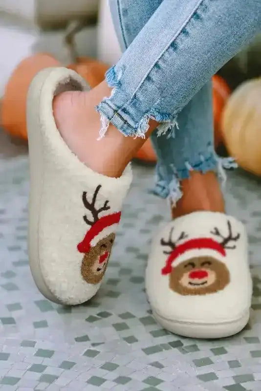 Side view of white Christmas deer plush slippers featuring reindeer face with red nose and antlers, ideal for holiday lounging indoors.