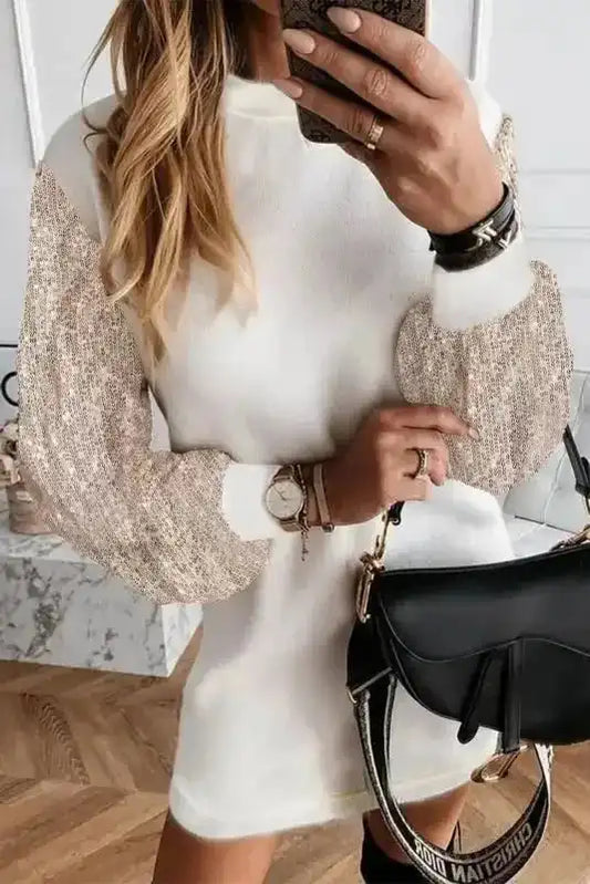 White Sequin Puff Sleeve Dress with shift mini silhouette and glittery long sleeves, styled with black handbag and accessories.
