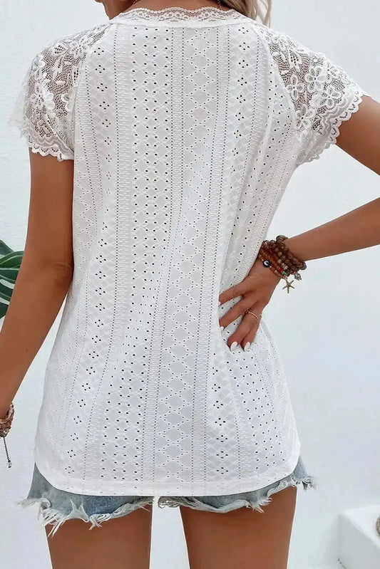 Back view of women’s white tee with floral lace sleeves and vertical eyelet pattern, offering a breathable and elegant fit.