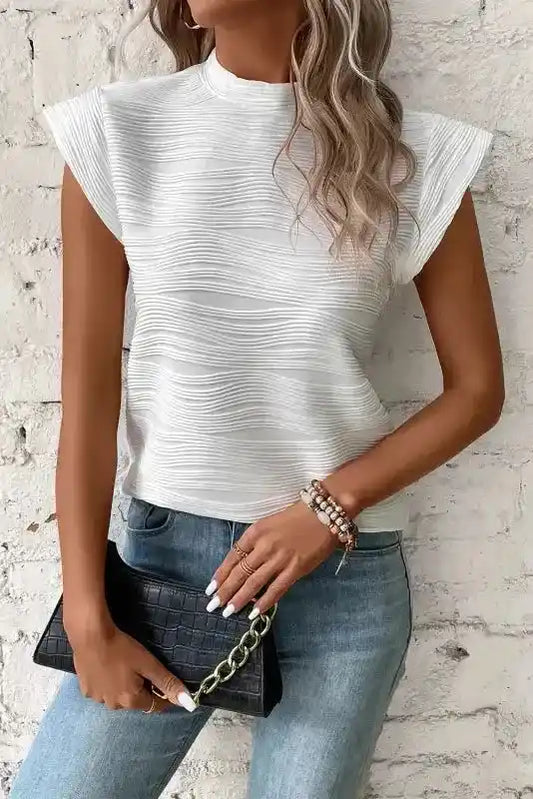 White Textured Mock Neck Top with cap sleeves styled with jeans and a black clutch, ideal for casual shift daily wear.