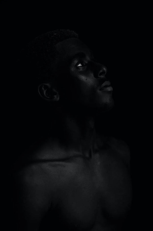 A contemplative portrait of a person against a dark background, inspired by the evolution of Victorian Corsets