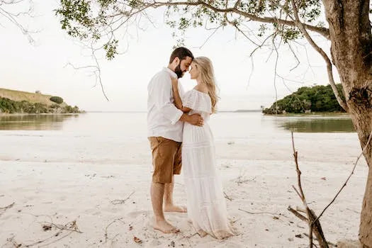 Couple on the beach embracing, illustrating dressing for body shape tips for romantic occasions