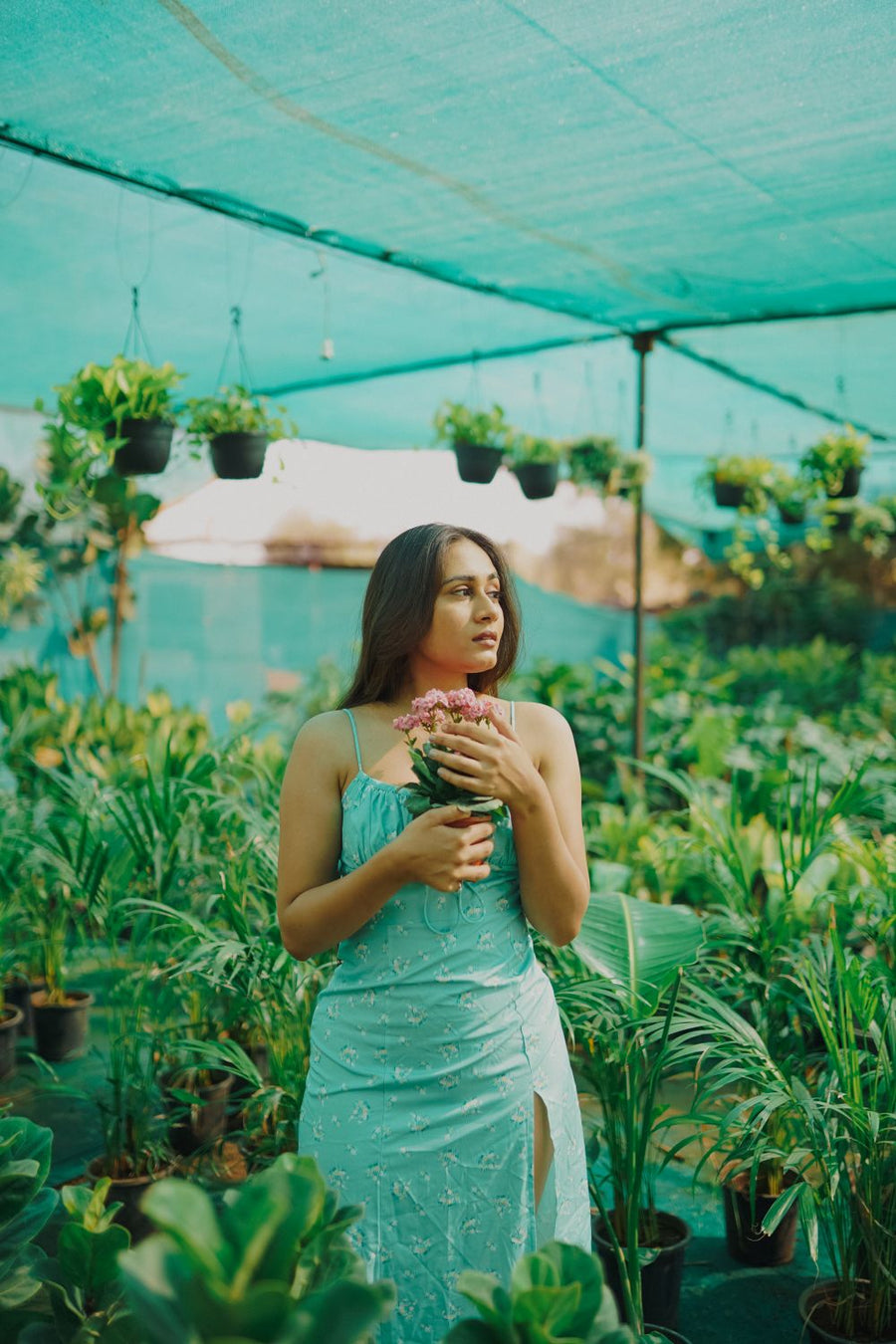 Woman in boho botanical dress among plants summer 2026