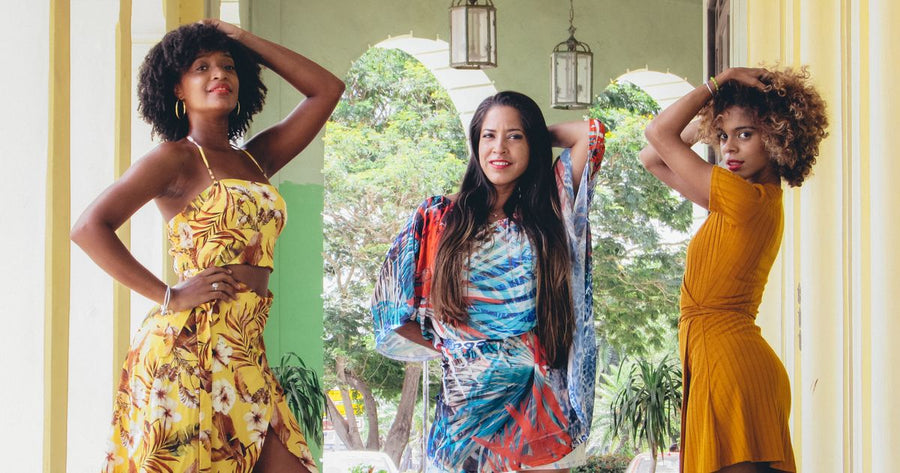 Three women in elegant floral dresses posing outdoors - UK garden party outfit 2026