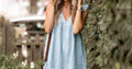 Woman in stylish minimal summer mini dress outdoors - hot weather fashion 2026