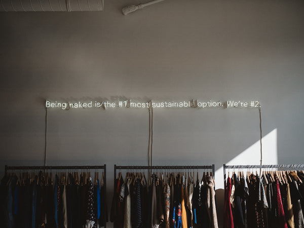 assorted clothes lot on gray clothes racks