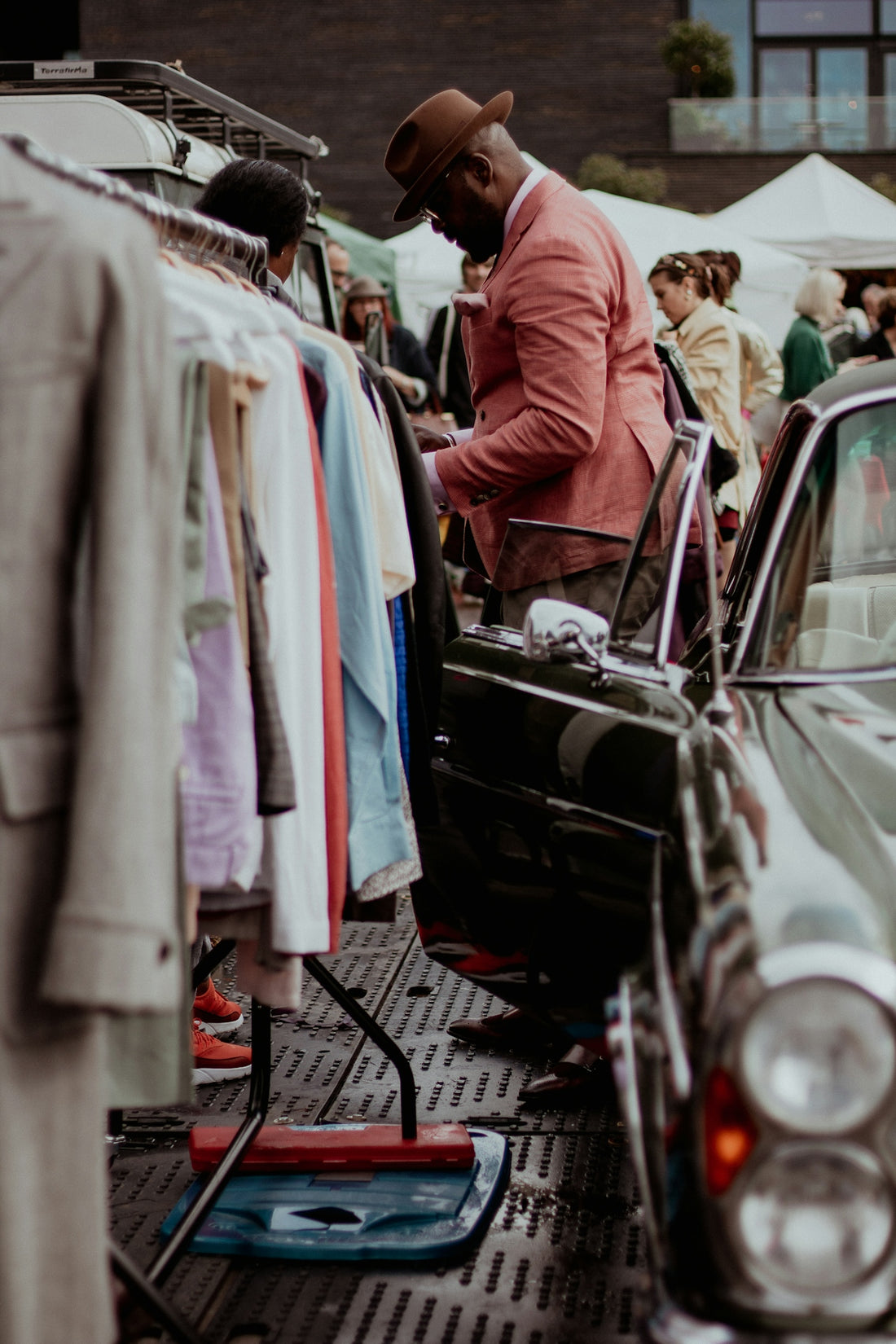 a man standing next to a car in a parking lot